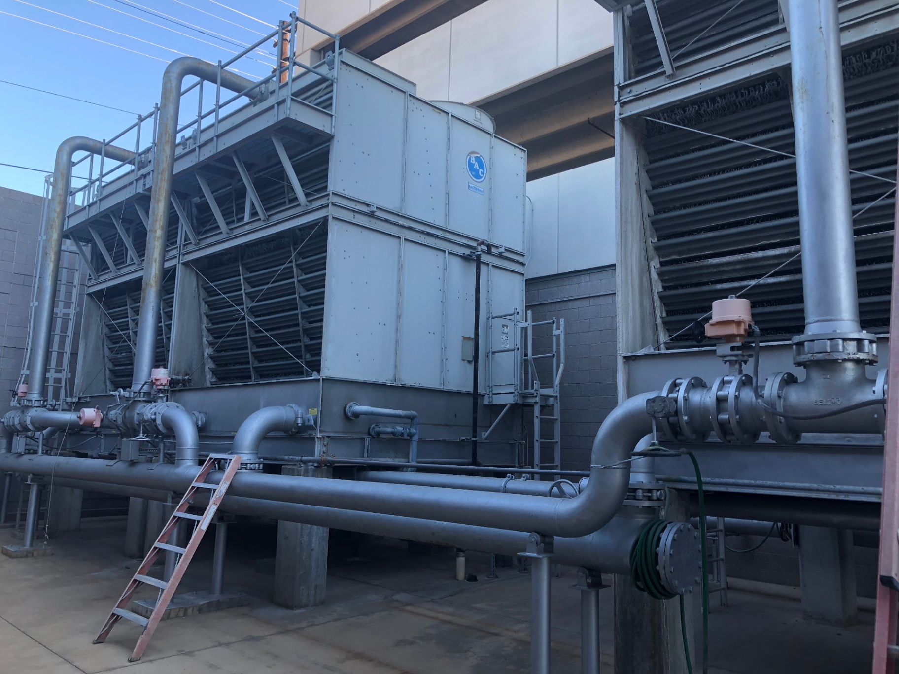 BAC cooling towers and condenser water piping on a commercial rooftop yard